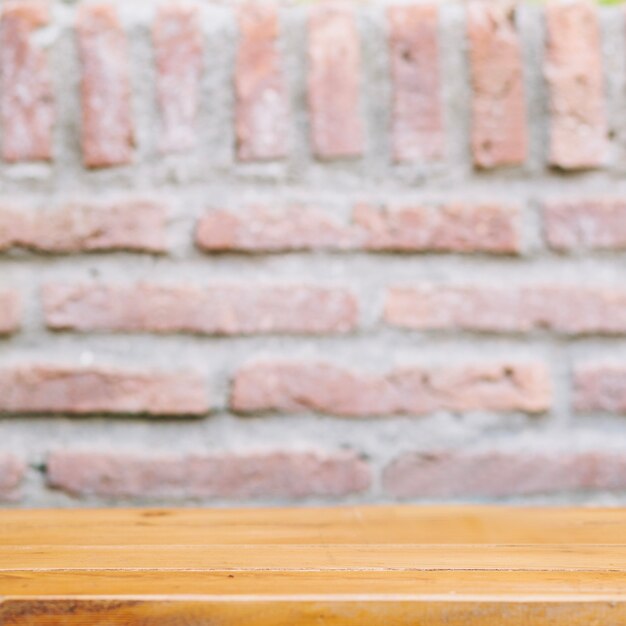 Wooden tabletop near brick wall