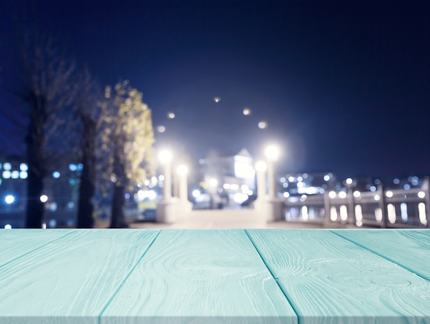 Wooden textured desk in front of city light at night