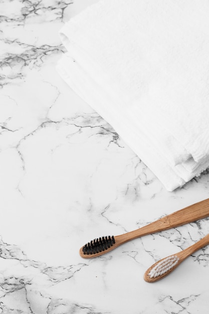 Wooden toothbrush and white towels on marble surface