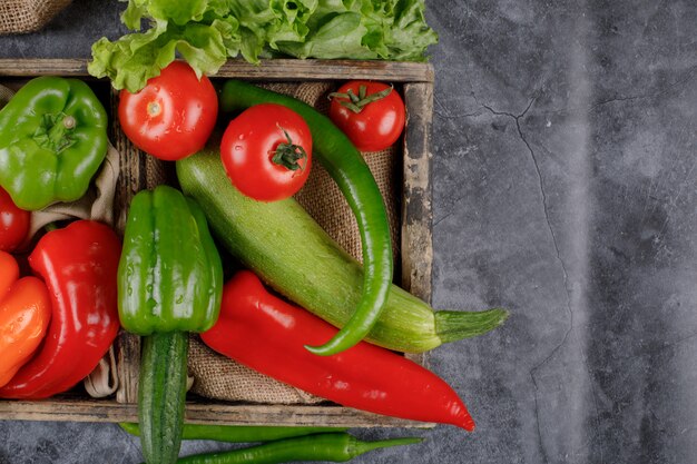 A wooden tray of red and green vegetables.