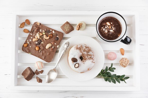 Wooden tray with breakfast and assortment of chocolate