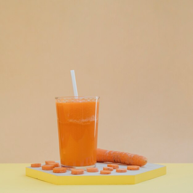 Wooden tray with carrot slices and juice