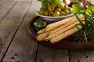 Free photo wooden tray with crusty bread and other aperitives