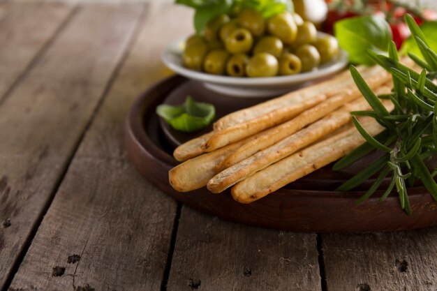 Wooden tray with crusty bread and other aperitives