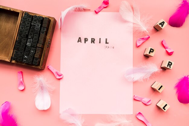 나무 인쇄상의 블록; 풍선; 깃; 4 월 블록 및 분홍색 배경으로 흰 종이에 4 월 스탬프