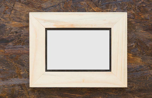 Free photo wooden white frame on textured wooden backdrop