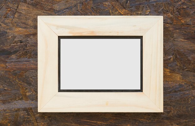 Wooden white frame on textured wooden backdrop