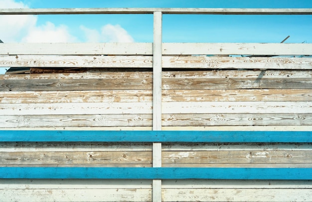 Free photo wooden wood wall texture background vintage tone or blank template the wall of the old barn in the bright sun weathered and sunbleached wooden boards with remnants of old blue and white paint