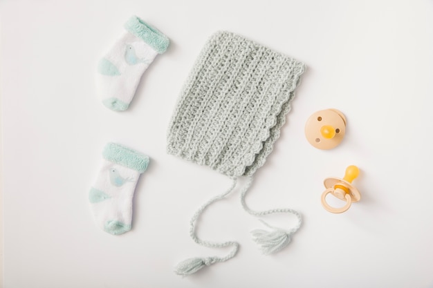 Woolen headwear; socks and pacifiers on white backdrop