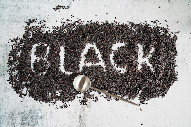 Free photo word black written on wild rice and spoon