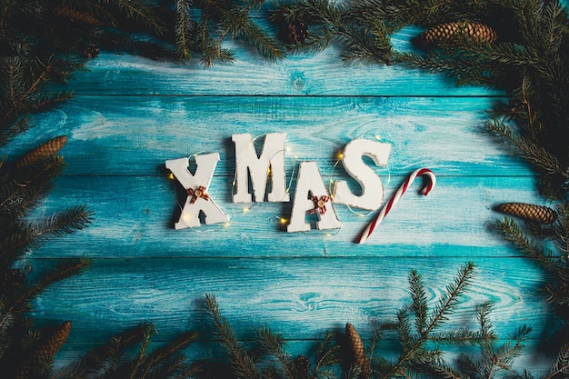 Free photo the word christmas. fir sprigs, candy cane, pine cones