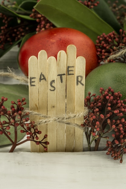 Foto gratuita la parola pasqua nel testo blocco concettuale su bastoni di legno