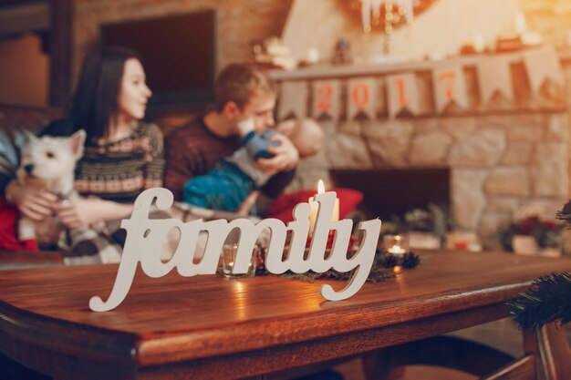 가족이 크리스마스에 백그라운드에서 소파에 앉아 단어 "가족"