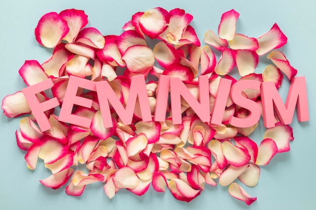The word feminism on top of rose petals
