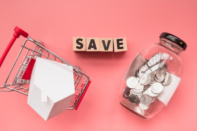 Free photo word made of wooden cubes with jar and shopping cart