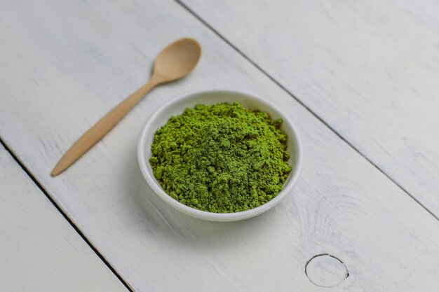 Word matcha made of powdered matcha green tea and bamboo spoon on white . Copy 