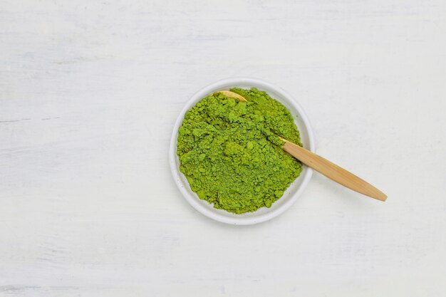 Word matcha made of powdered matcha green tea and bamboo spoon on white . Copy 