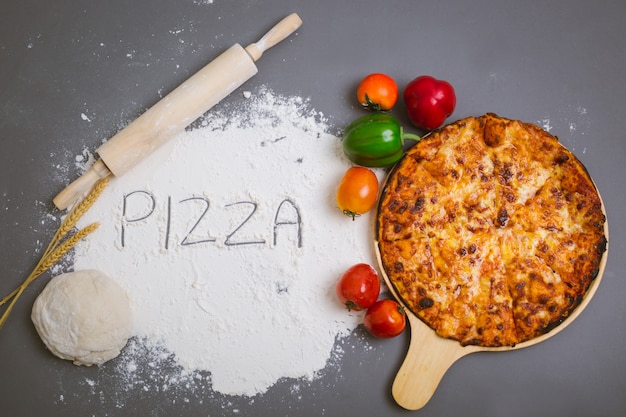 Foto gratuita esprima la pizza scritta su farina con una pizza saporita