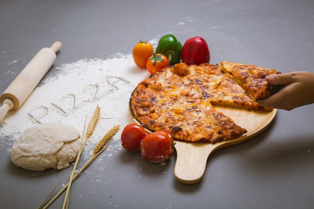 Word pizza written on flour with a tasty pizza