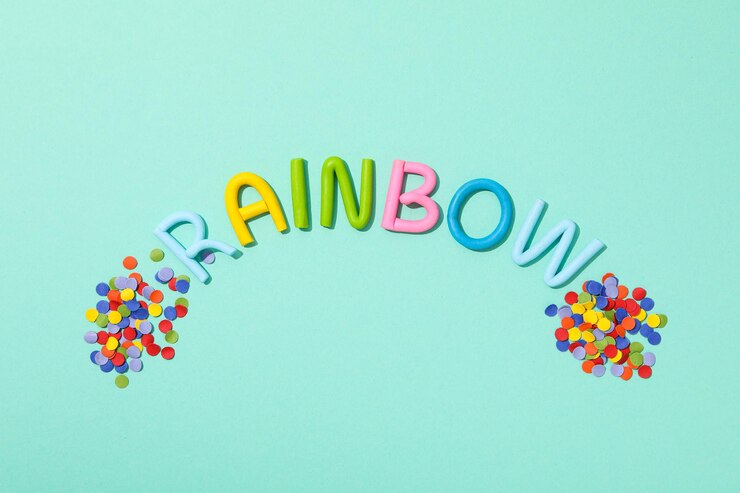 Free Photo the word rainbow is made of colored plasticine on a turquoise background