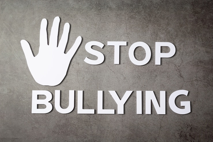 Free Photo word "stop bullying" with hand sign on dark wall