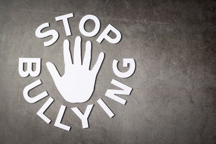 Free Photo word "stop bullying" with hand sign on dark wall