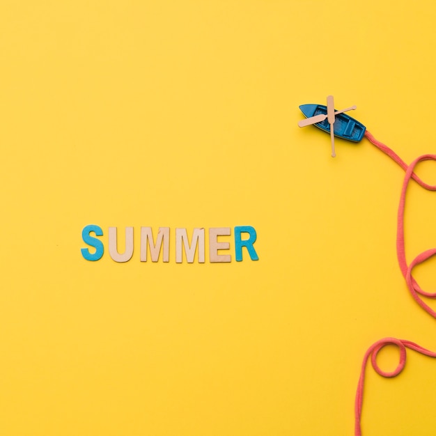 Бесплатное фото Слово лето с игрушечным кораблем