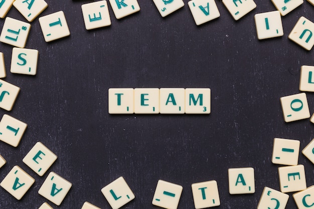 Foto gratuita team di word in lettere scrabble su sfondo nero