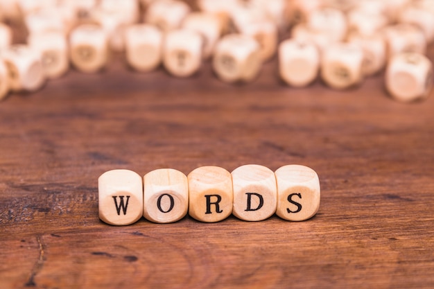 Word text on wooden dices above brown desk