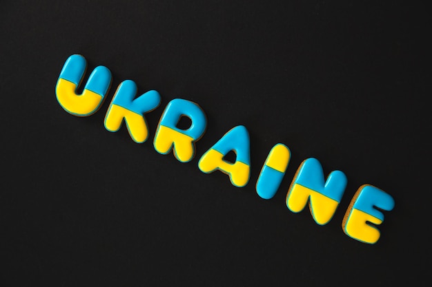 Free photo the word ukraine on a black background made with handmade gingerbread