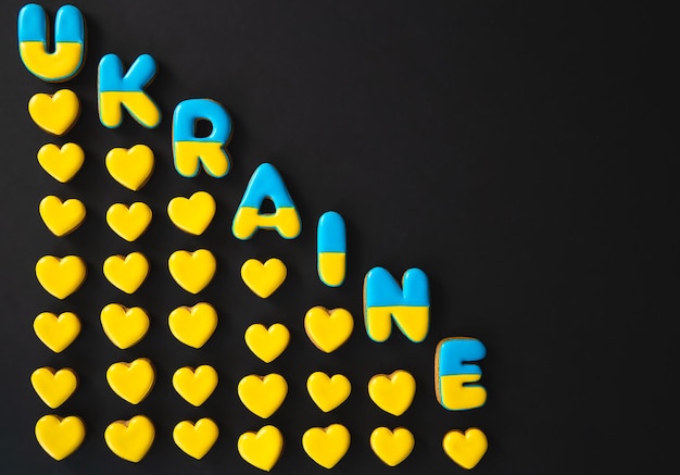 Free photo the word ukraine on a black background made with handmade gingerbread