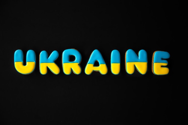 Free photo the word ukraine on a black background made with handmade gingerbread