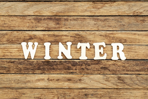 Free photo the word winter composed of wooden letters on a wooden background top view