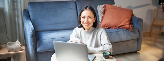 Free photo work from home freelance and elearning concept young woman studying sitting in front of laptop