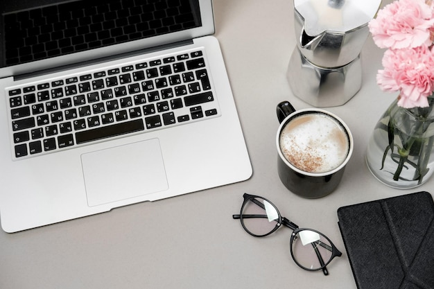 work space table with laptop phone and coffee on grey background top view flat lay