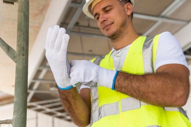 Foto gratuita lavoratore in un cantiere edile che indossa guanti