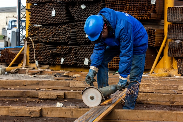 Il lavoratore taglia il ferro con l'attrezzo