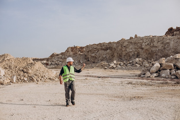 Free photo worker in hardhat standing in sand quarry