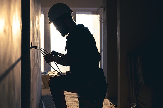 Worker is cutting wires with lineman's pliers.