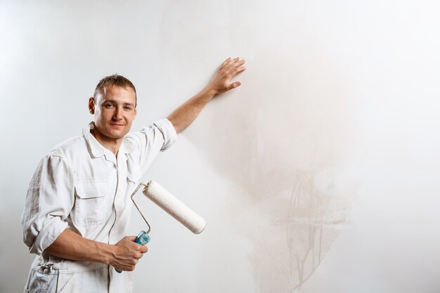 Worker looking at camera, holding roller.