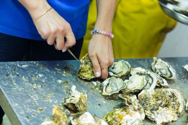 Free photo worker opening oysters