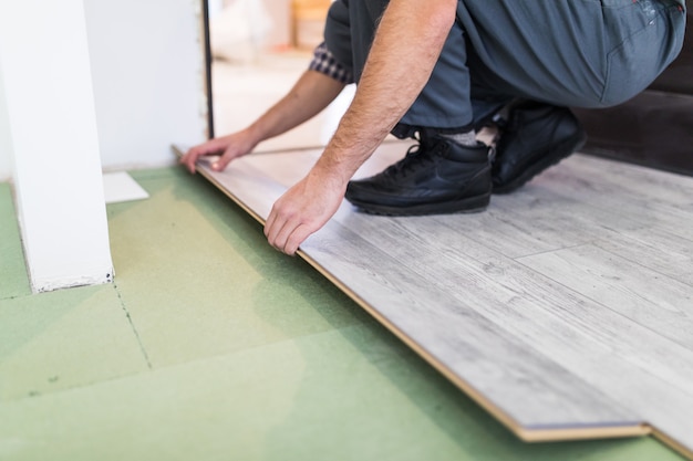 Worker processing a floor with laminated flooring boards