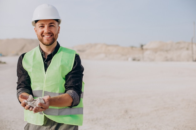 Free photo worker in sand quarry holding rocks