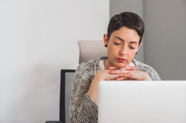 彼女のあごの下の手で考える労働者