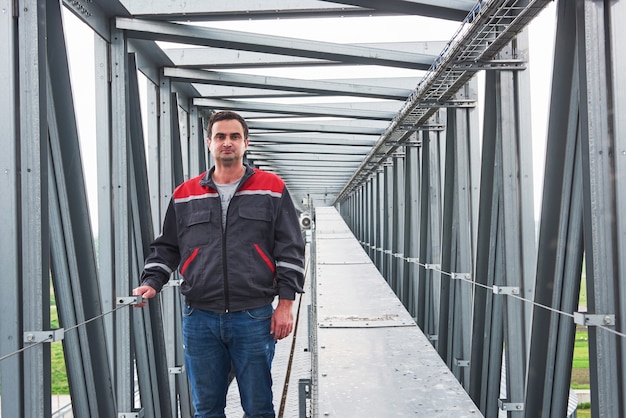 Worker in uniform against the backdrop agri buildings