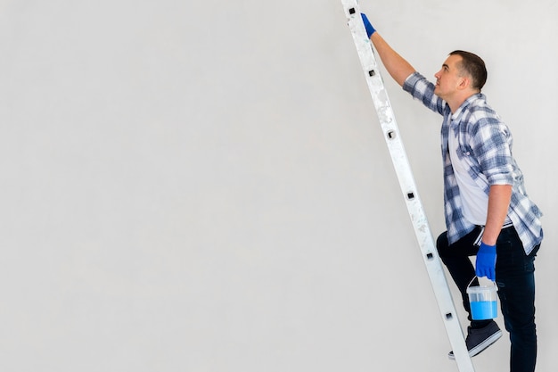 Free photo worker walking on stairs carrying paint