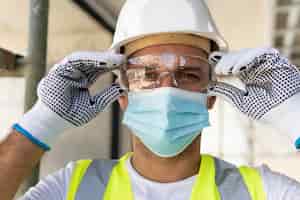 Foto gratuita lavoratore che indossa occhiali di sicurezza in un cantiere edile