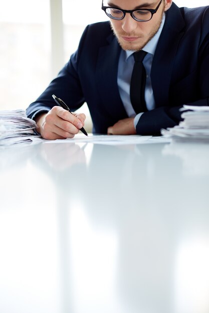 Worker with glasses signing a contract