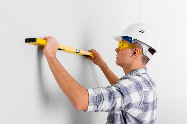 Worker with spirit level on a wall