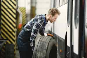 Free photo worker with a wheel. wheel replacement. man in uniform